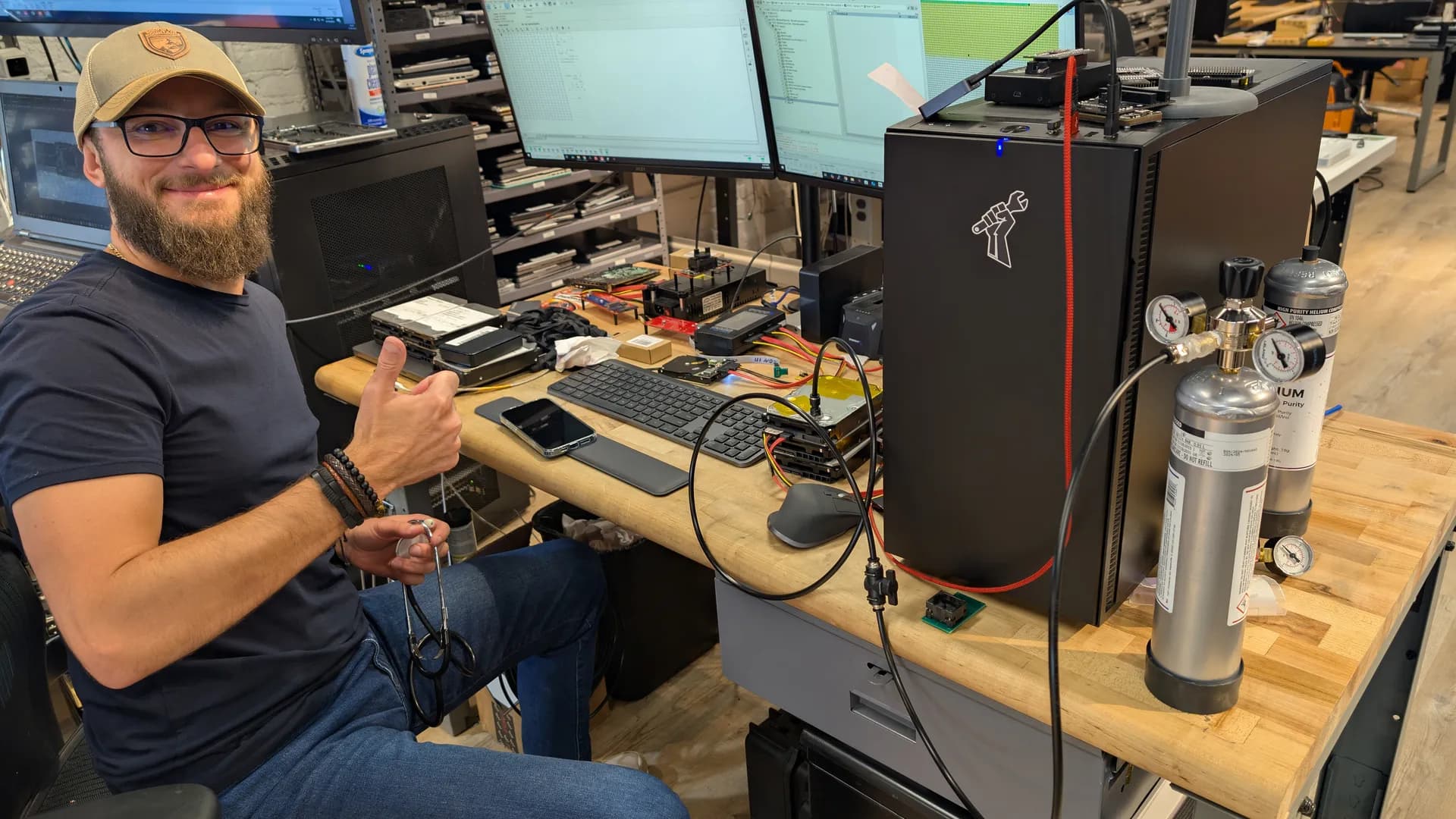 Louis Rossmann at the helium drive workstation in the Austin lab with the helium recharge manifold and ULPA-filtered laminar flow bench